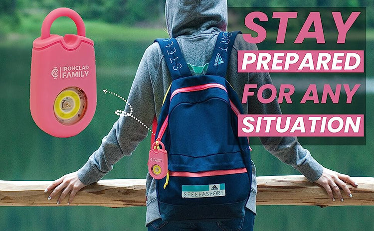 A person with a backpack carrying a pink personal alarm keychain for preparedness