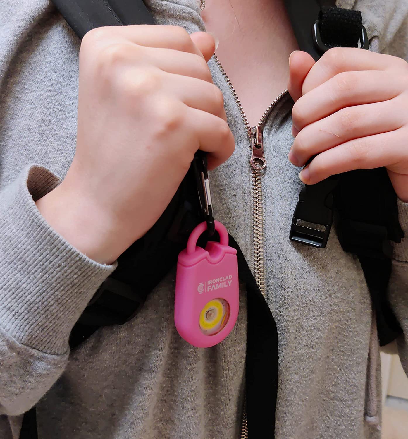Close-up of a hand holding the pink personal alarm sound pendant keychain