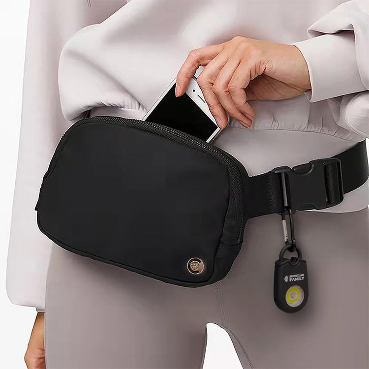 Woman carrying a phone in the waist bag of the Personal Alarm with Fanny Pack Crossbody Belt Bag