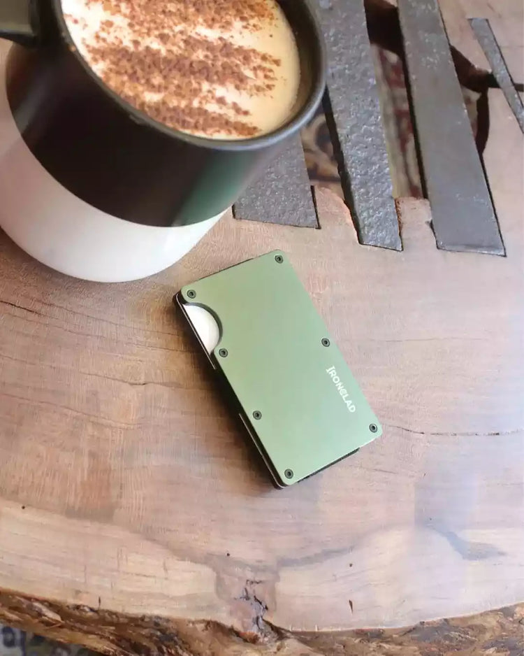 Coffee cup next to the matte metal RFID blocking wallet on a table